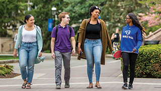 A group of undergraduate students walking on campus. A group of undergraduate students walking on campus.