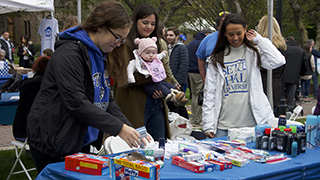 Students volunteering at an on campus event with alumni