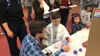 IMG_2944(320x180) Andrew D’Amato (bottom left) teaching a young chemist whilst the judges look on.