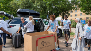Move-in-day-parents-volunteers-320x180 Image of volunteers, parents, and Sister Ann helping move bins out of a car during Move-In Day 2022.