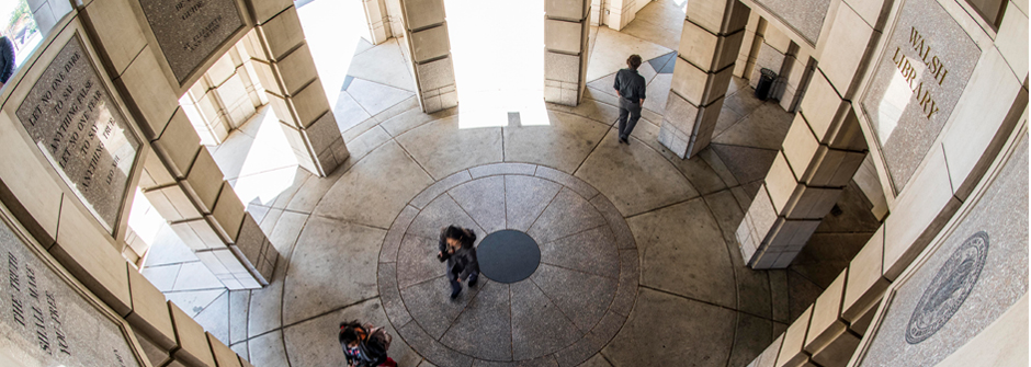 Image of the Walsh Library's rotunda from the top down with students walking through it.