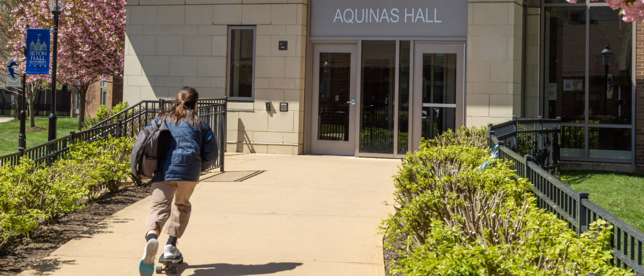 Aquinas Hall Aquinas Hall with a student skateboarding into it.