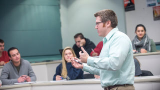 Business class Professor addressing a group of students in a business class.