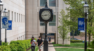 Image of two students walking across campus.