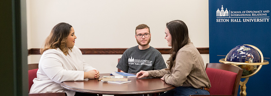 Diplomacy students working in a small group around a conference table.