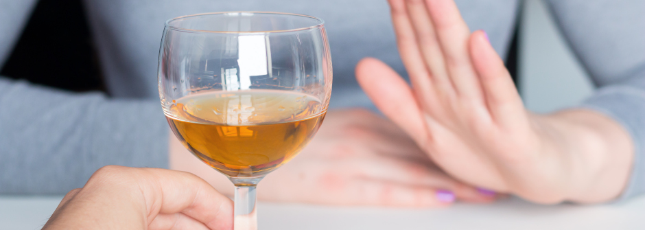 An image of a man offering a drink to a woman who is not interested.