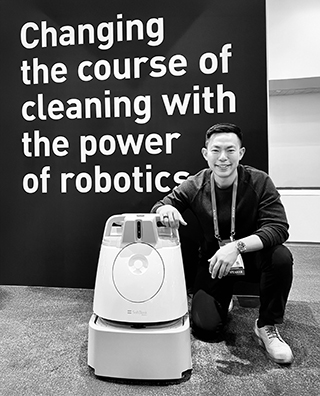 Jordan Sun posing with a robot.