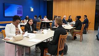Students sitting on a table with professionals during interview simulations