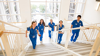 Nursing students in scrubs walking upstairs Nursing students in scrubs walking upstairs
