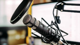 Microphone Microphone with a laptop in the background