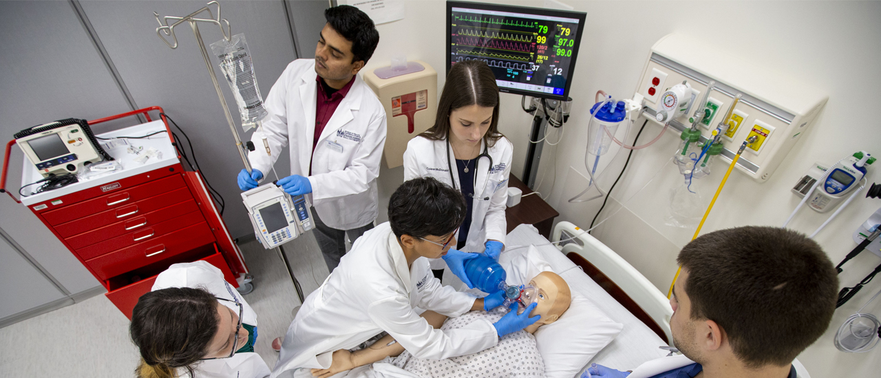 Health students working on a practice dummy Health students working on a practice dummy