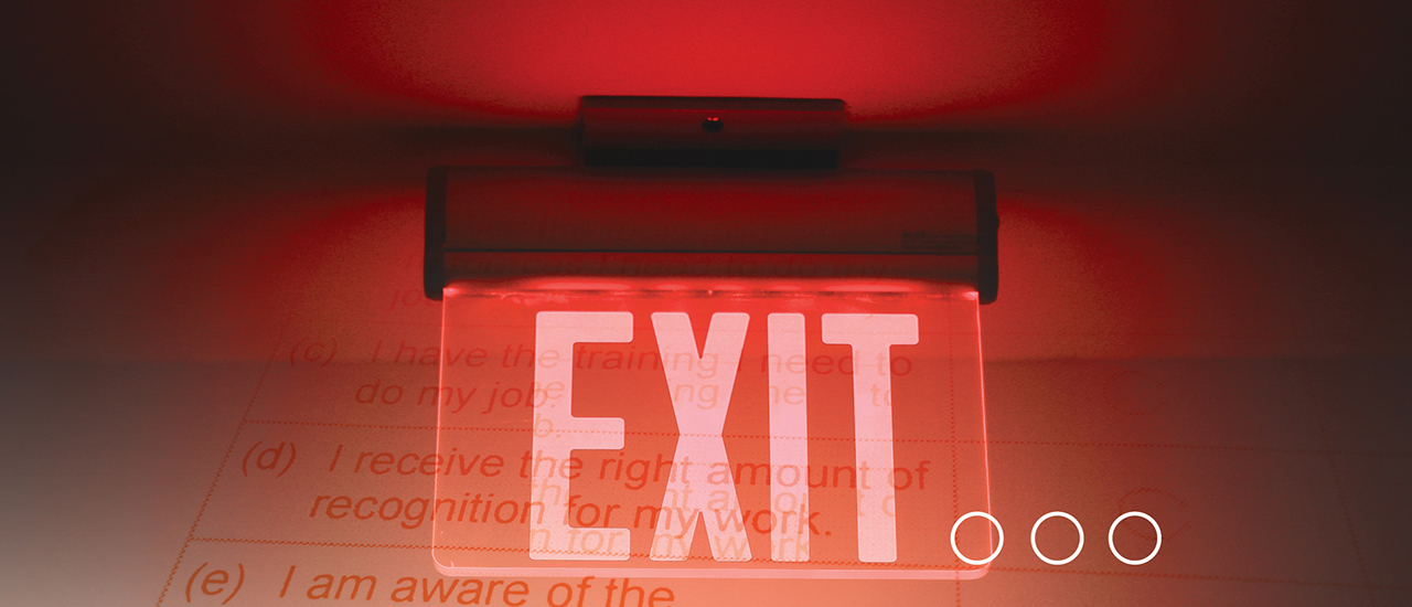 Red Exit Sign An exit sign that is lit up in red lighting.