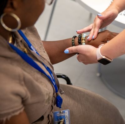 SHU occupational therapy student holds a patient's hand