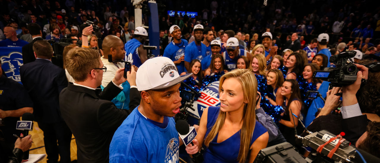 Student interviewing basketball player Derrick Gordon after the Big East Tournament win.