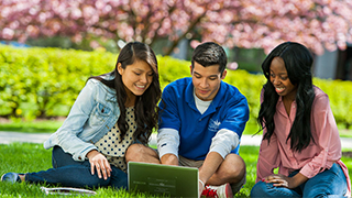 Students sitting at a laptop in the spring