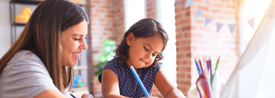 An educator and a student drawing with colored pencils.